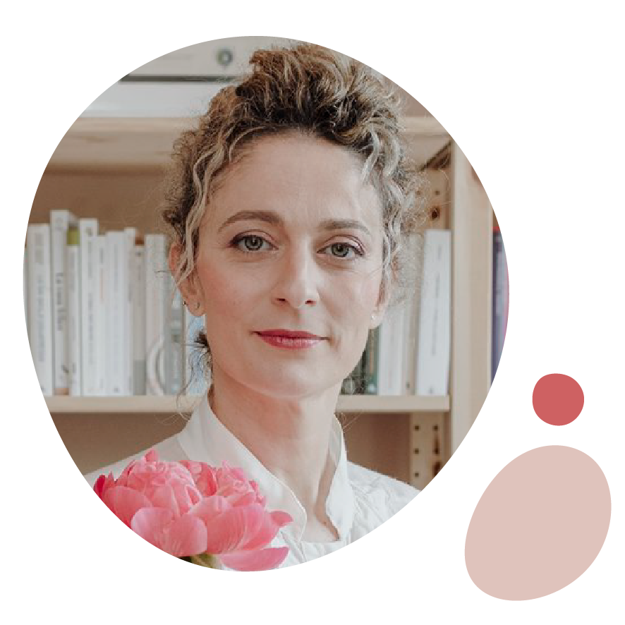 Francesca Campese, interior coach, sorride con un mazzo di peonie rosa davanti alla sua libreria