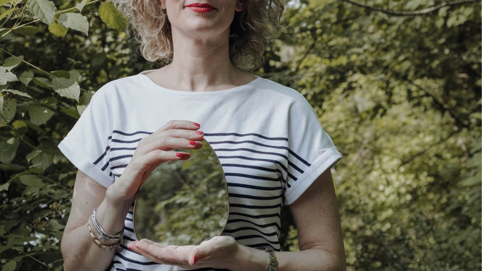 Francesca Campese, interior coach, tiene uno specchio tra le mani in giardino: la casa come specchio di chi la abita.
