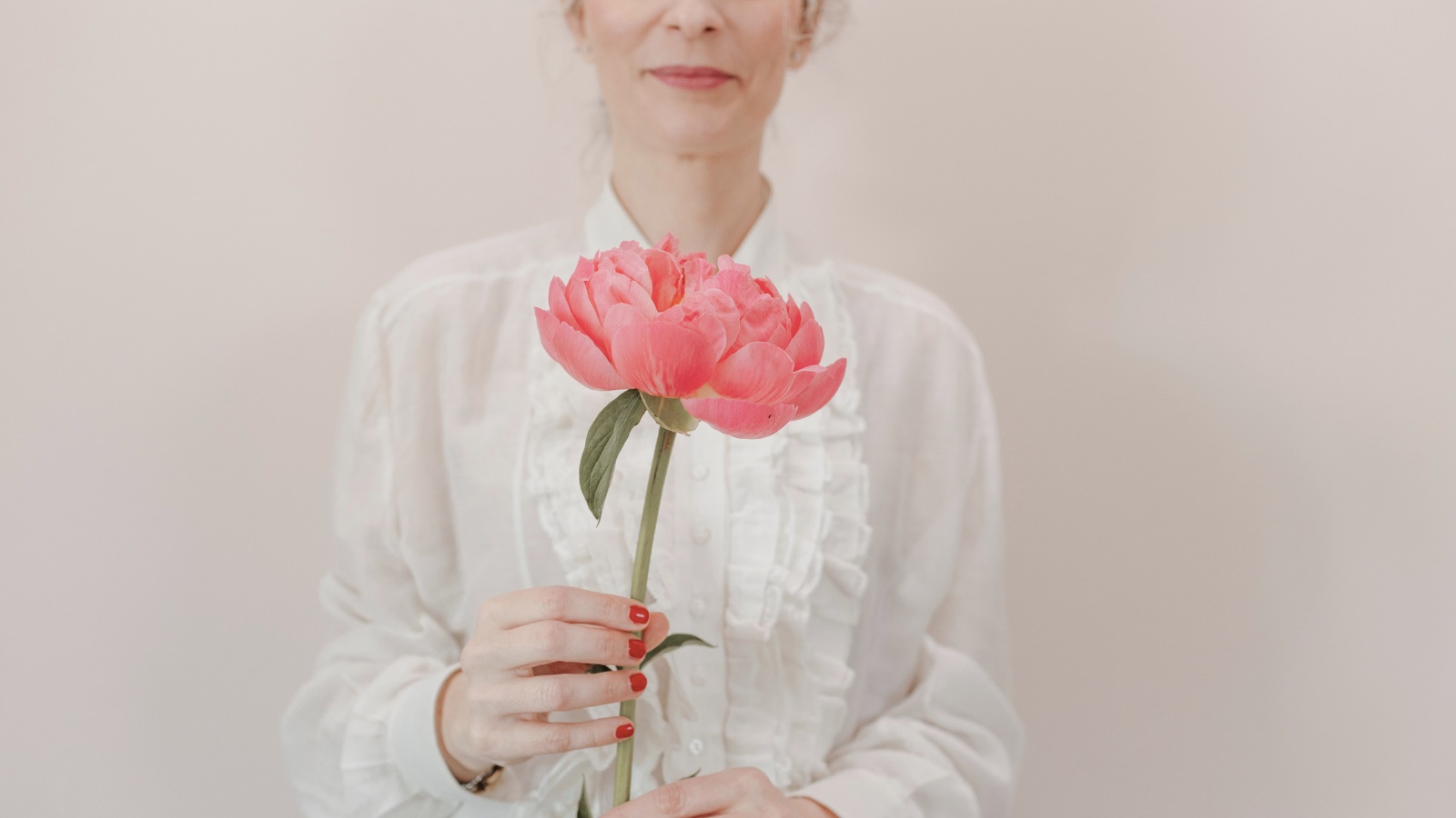Francesca Campese, interior coach, tiene tra le mani una peonia rosa